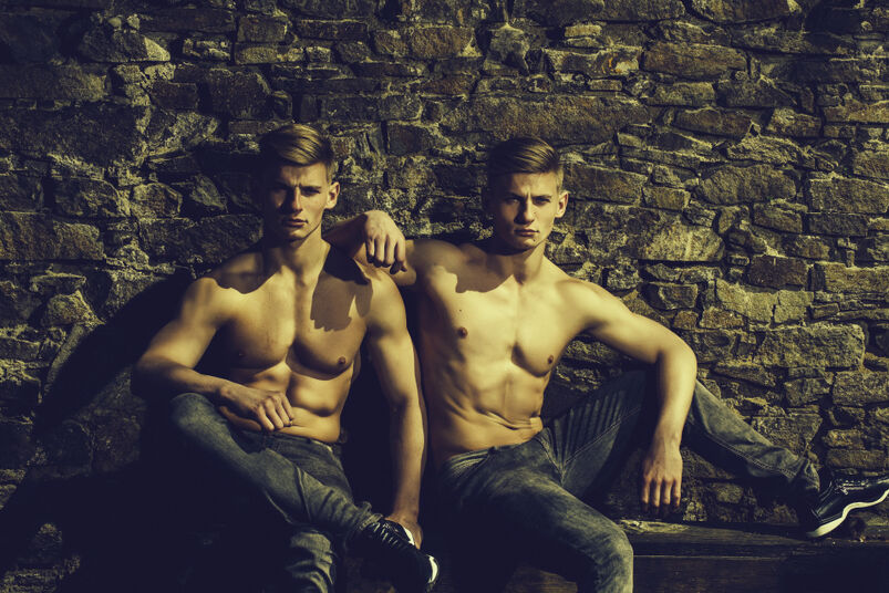 Twincest: Twin brothers young sensual serious with bare chest in jeans pose outdoor