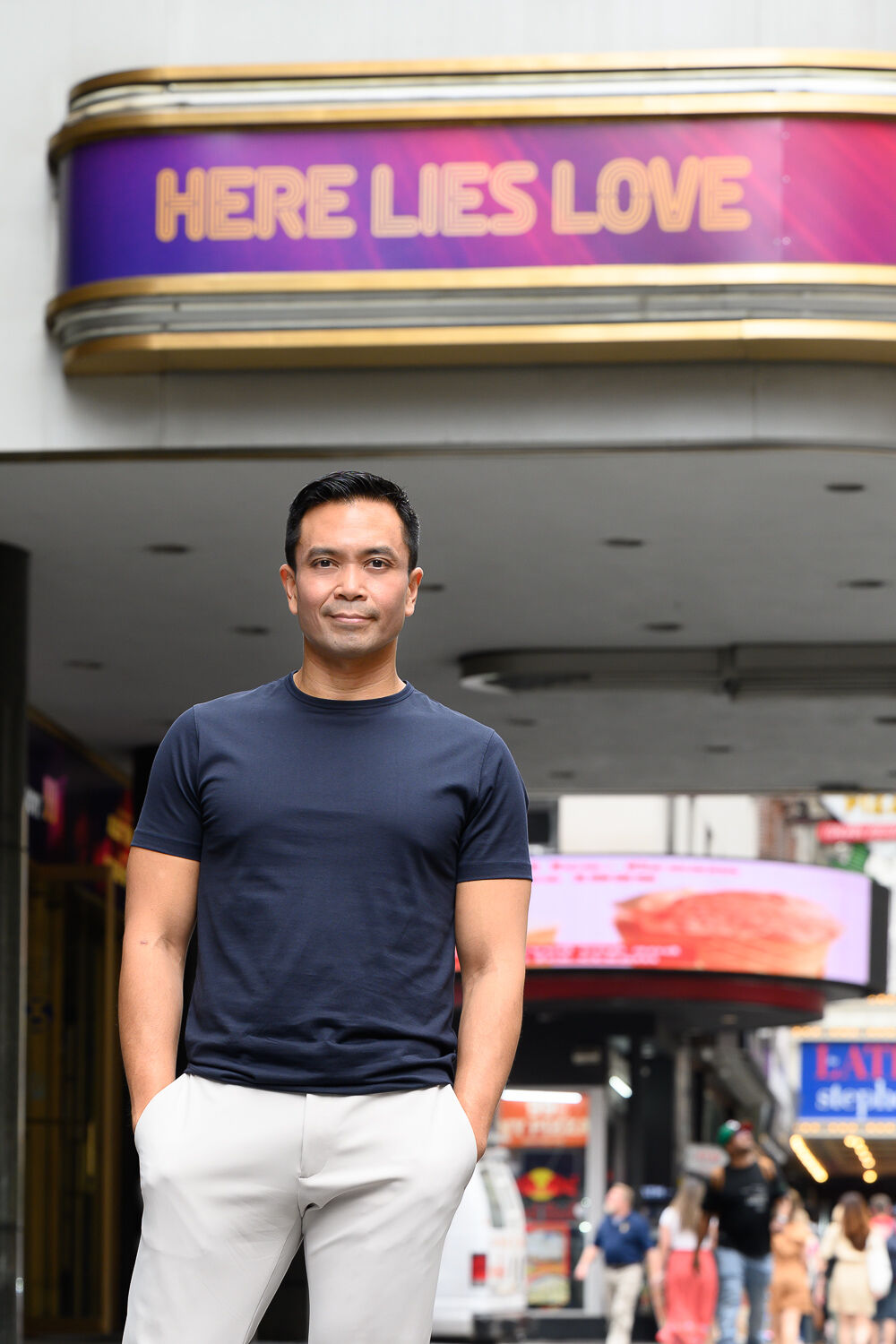 Jose Llana stands in front of the marquee for "Here Lies Love" at the Broadway Theatre.