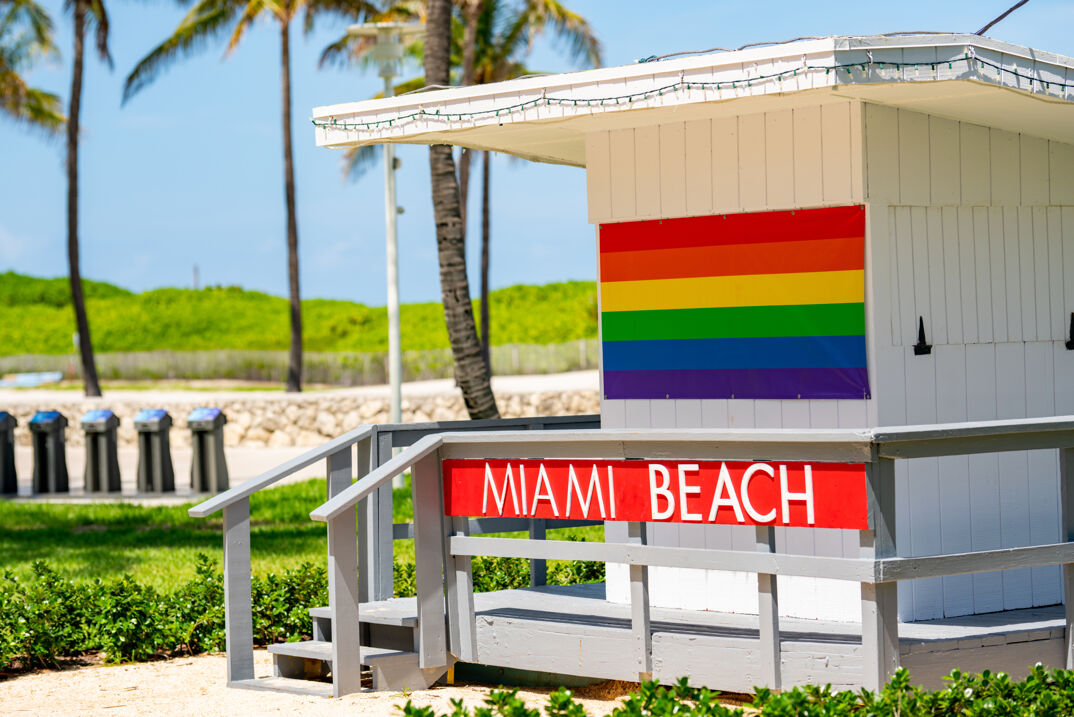 Miami Beach sign above the Rainbow Pride Flag.