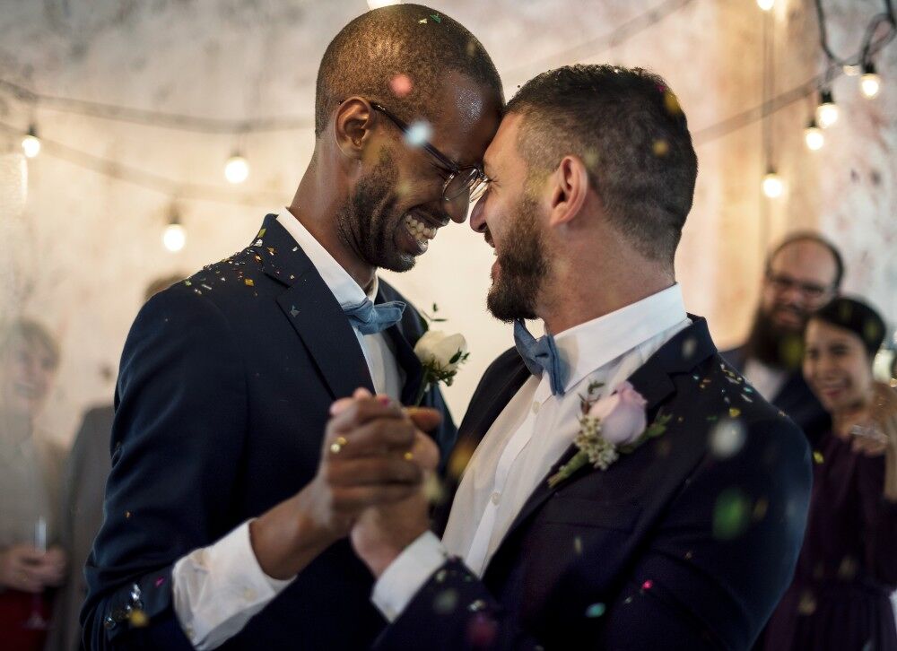 A gay couple dance together at their wedding