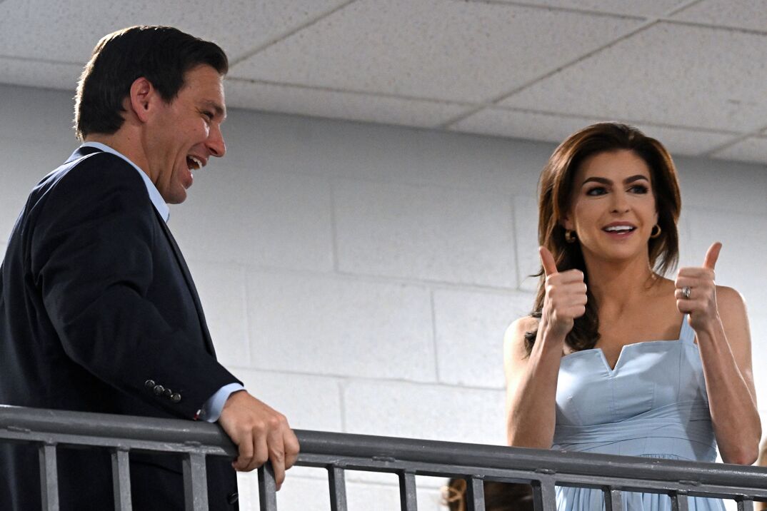 Casey Desantis wearing a blue dress giving two thumbs up.