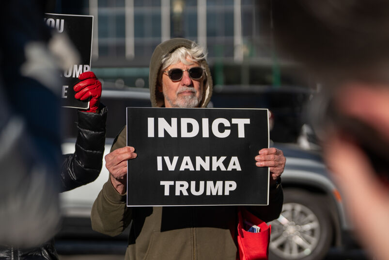 Man holding sign that reads "Indict Ivanka Trump"