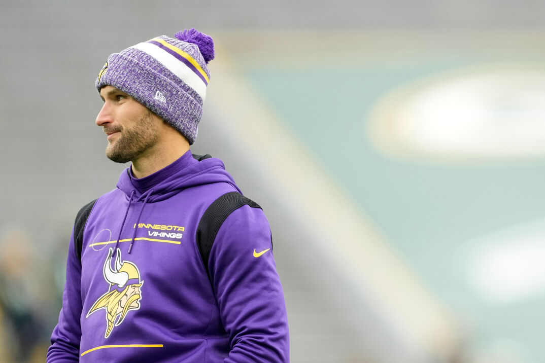 Minnesota Vikings QB Kirk Cousins dressed in a winter hat and wearing a purple sweatshirt with the Vikings logo. 
