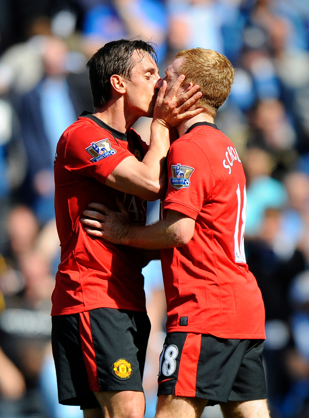 Gary Neville kisses scorer of the winning goal Paul Scholes of Manchester United at the end of a match on the field. 