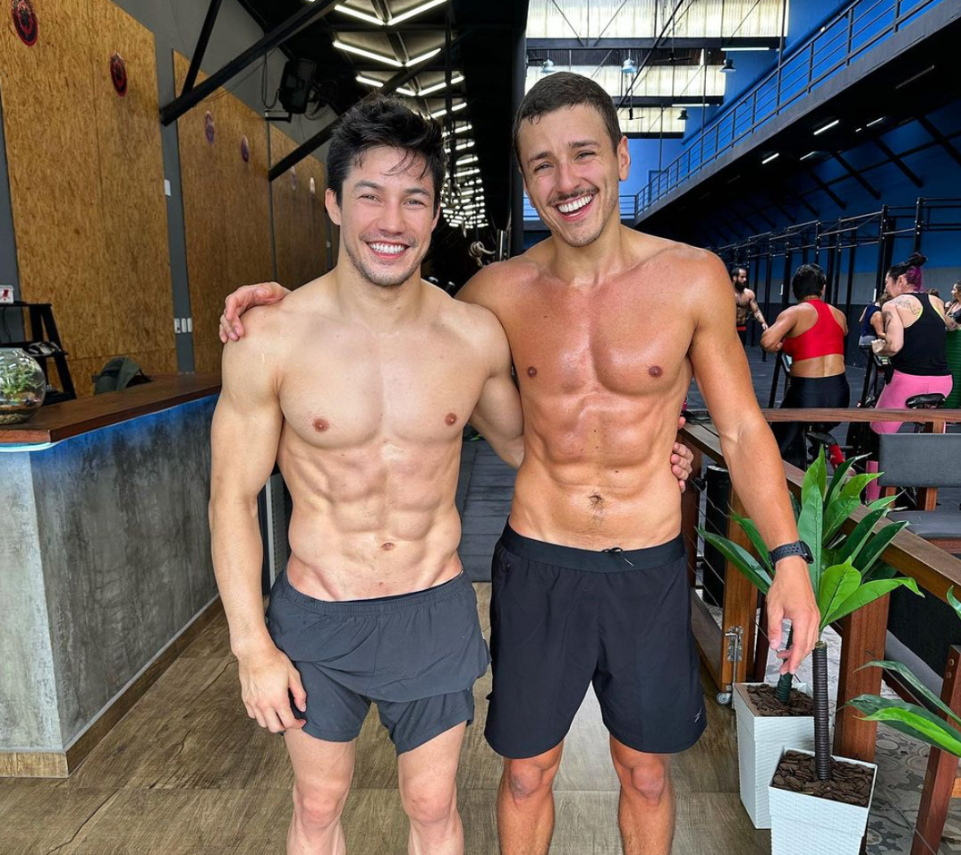 Arthur Nory (left) posing shirtless with his boyfriend João Otávio Tasso (right), who's also shirtless.