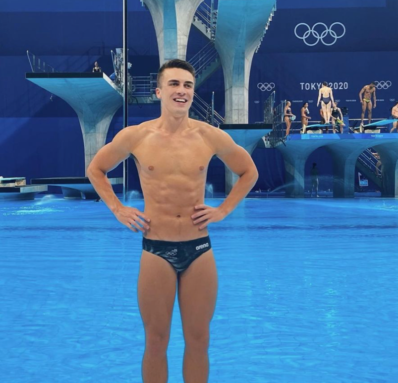 Diver Anton Down-Jenkins standing outside of the pool in a dark speedo. 