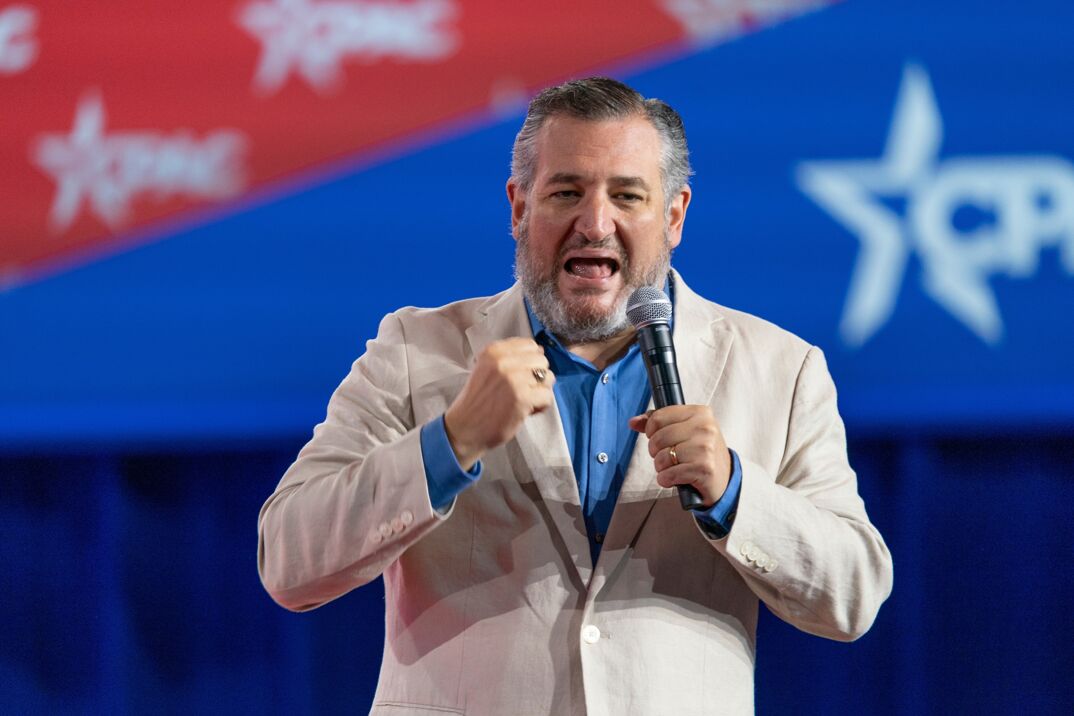 Ted Cruz wearing a white jacket and blue shirt blabbing into a microphone.