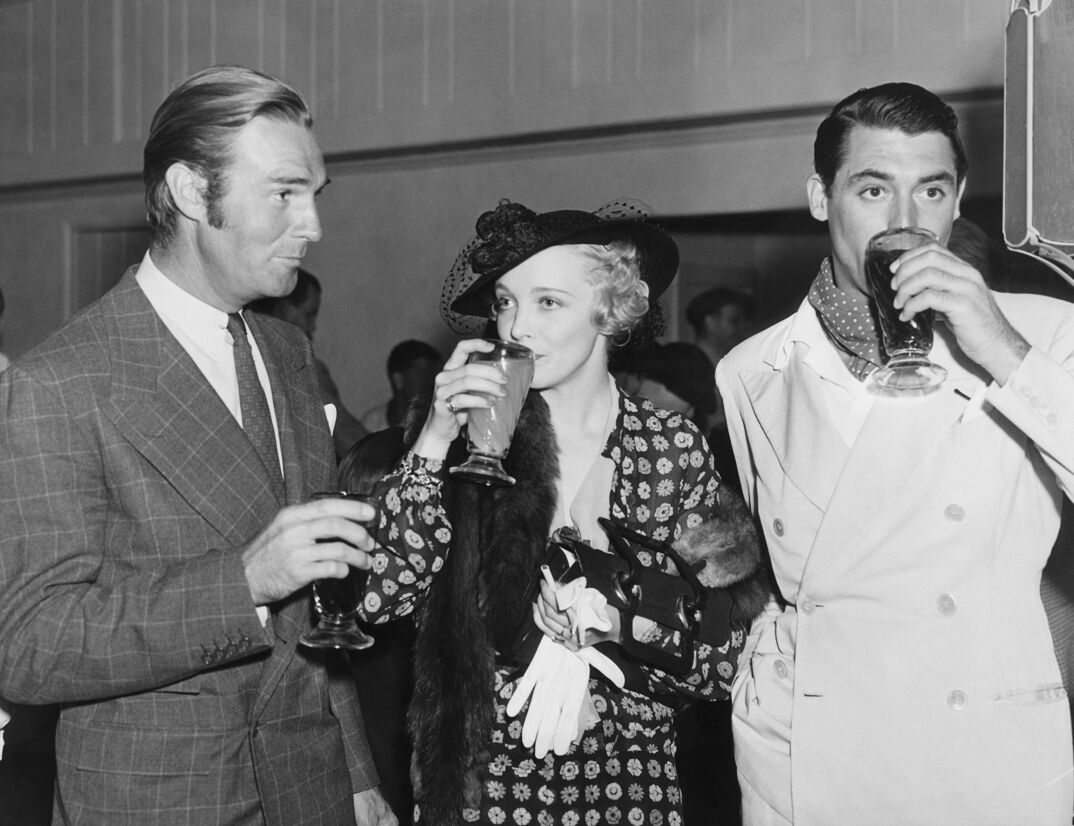 Movie stars Randolph Scott, Virginia Bruce and Cary Grant enjoying beverages at a Hollywood event, Hollywood, California, circa 1936. (Photo by Underwood Archives/Getty Images)