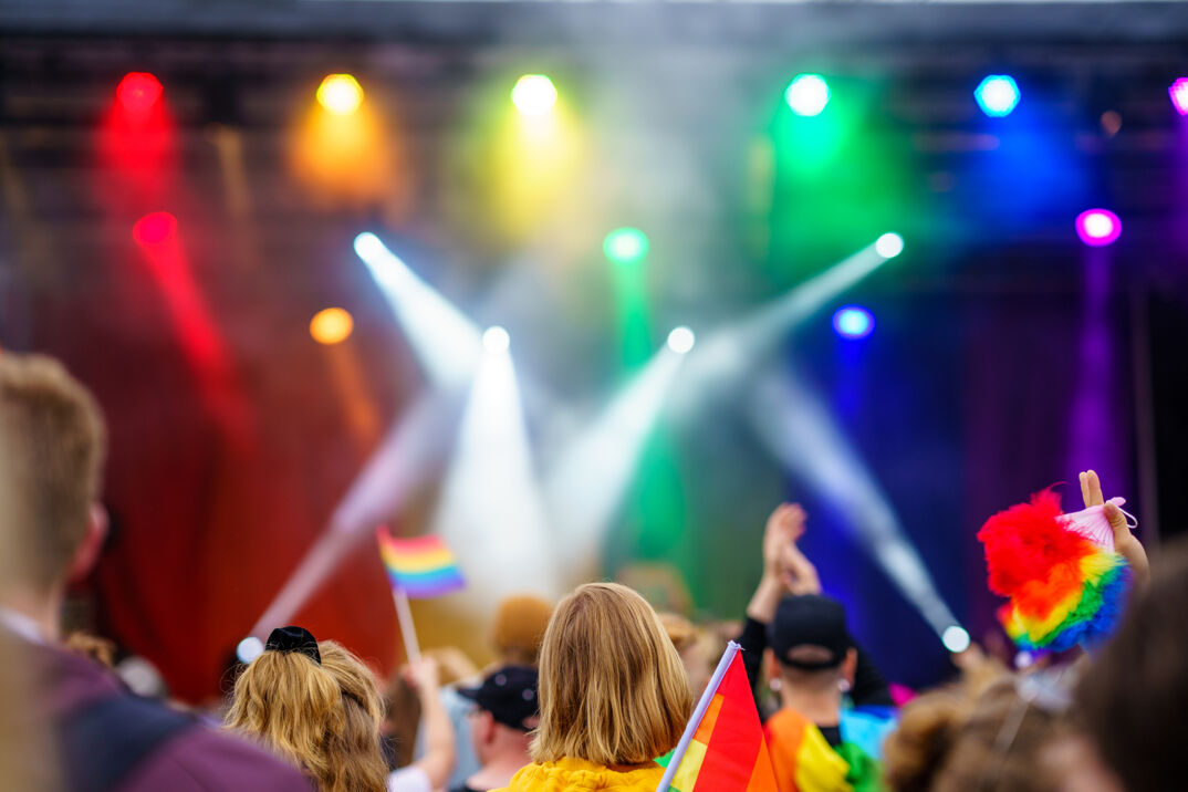 A performance featuring bright flags and vibrant rainbow lights.