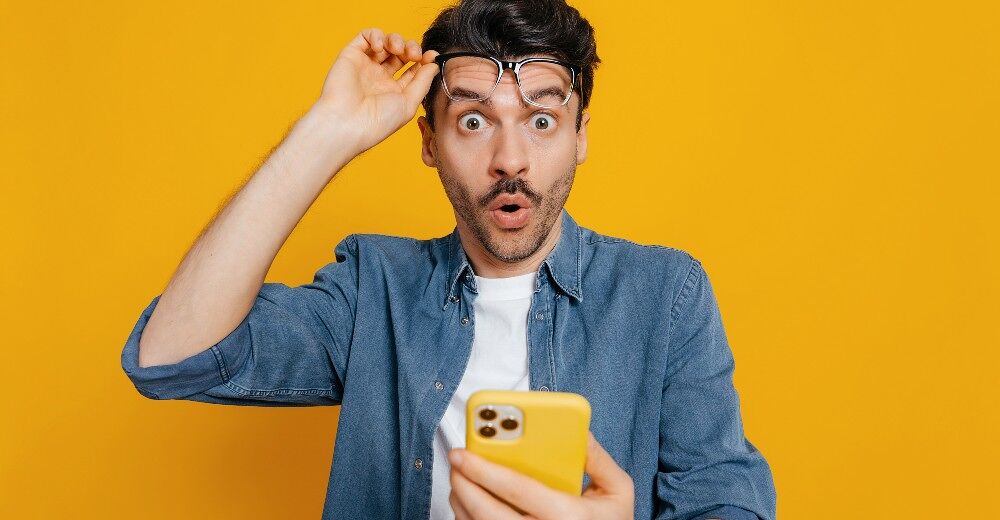 A man looks susprised after checking his phone