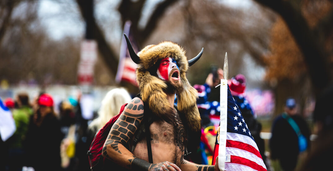 The QAnon Shaman standing and protesting outside of the U.S. Capitol. 