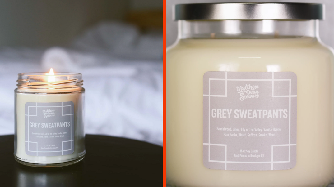 Two-panel image. In the left panel, a lit white soy candle sits in a glass container on a brown bedroom nightstand. The silver label on the candle reads "Matthew Dean Stewart / Grey Sweatpants." In the right panel, the same candle is pictured as a closeup to reveal further details on the label.