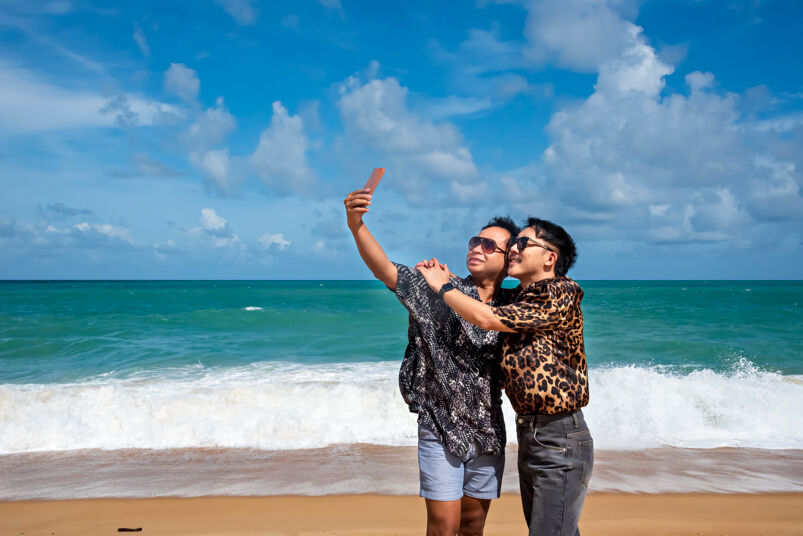 Same sex couple are taking selfie on their holiday.