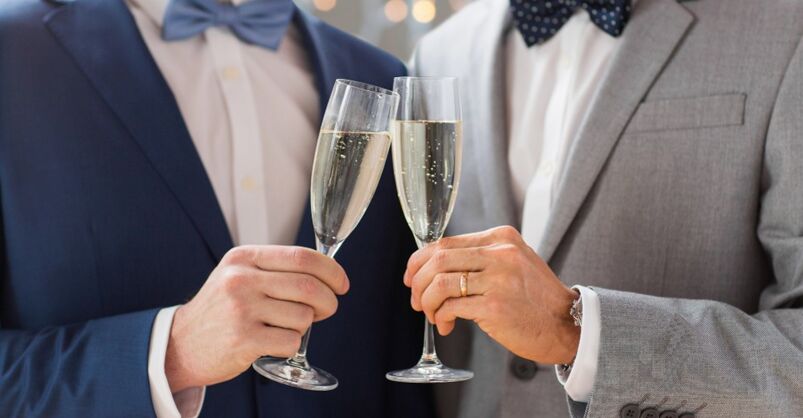 Two men clinck champagne classes at a same-sex wedding