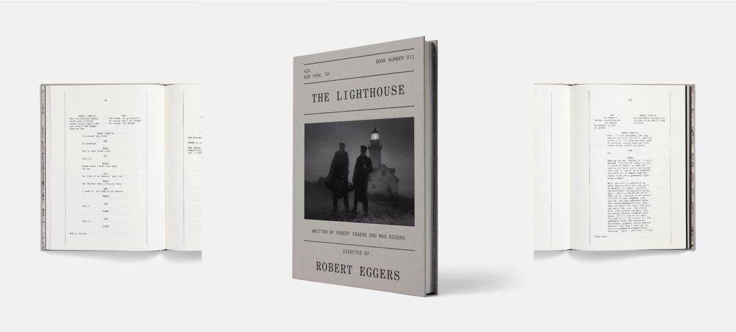A gray hardcover book in the center of a gray background with a picture of two silhouettes on the cover. In capital letters: "The Lighthouse" and "Screenplay by Robert Eggers." On the left and right, the same book is flipped open to reveal indiscernible black and white pages of a script.