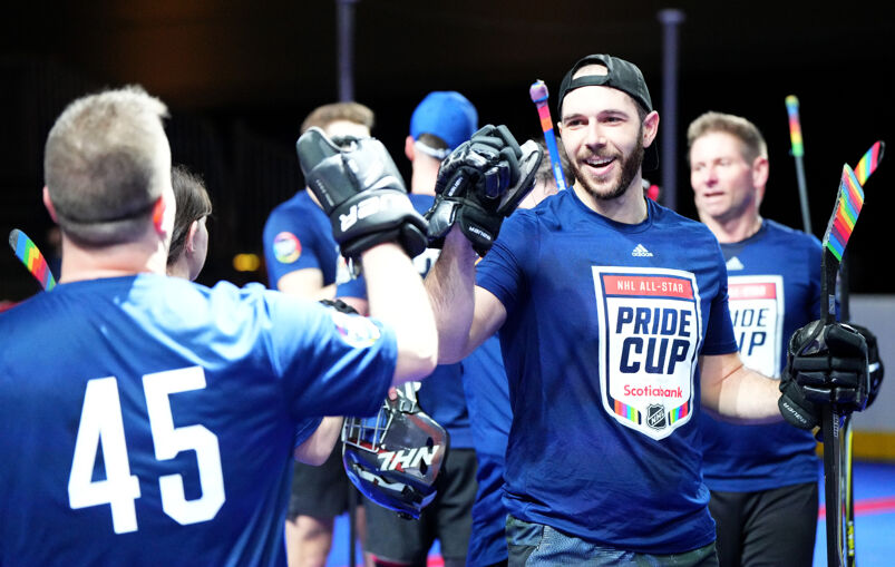 Gay hockey players wearing blue NHL Pride Cup shirts. 