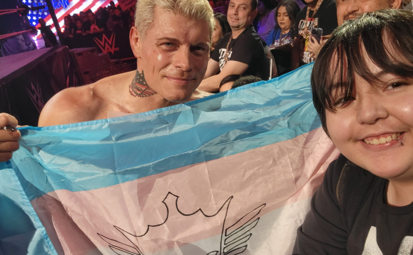 Cody Rhodes holding up a transgender Progress flag. 