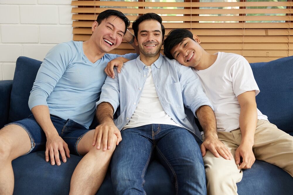 Three men cuddling on couch