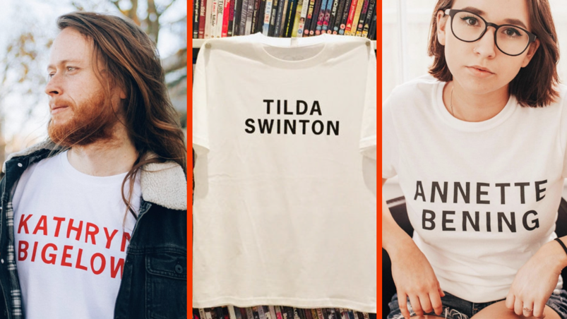 Three-panel image. In the left panel, a man with long brown hair and a red beard looks off outdoors in New York. He wears a white t-shirt that simply reads "Kathryn Bigelow" in red letters under a denim jacket. In the middle panel, a similarly styled t-shirt pictured in front of a shelf of DVDs reading "Tilda Swinton" in black letters. In the right panel, a woman with black-framed glasses sits at a desk. She has short brown hair and smirks, wearing a similarly styled shirt as the others that reads "Annette Bening" in black letters.