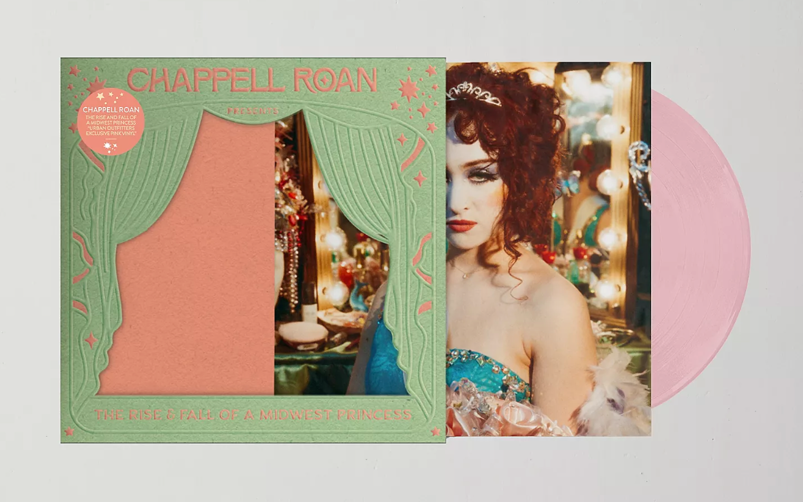 Over a gray background, the vinyl album for "The Rise and Fall of a Midwest Princess" by Chappell Roan is pictured. Roan is depicted as a pageant queen in a blue dress with curly brown hair, a crown, and a white-painted face peeking through green curtains. A pink vinyl disc peeks out from the sleeve.