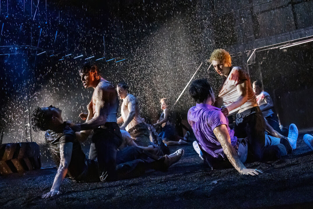 A fight scene in the rain from "The Outsiders" musical on Broadway.
