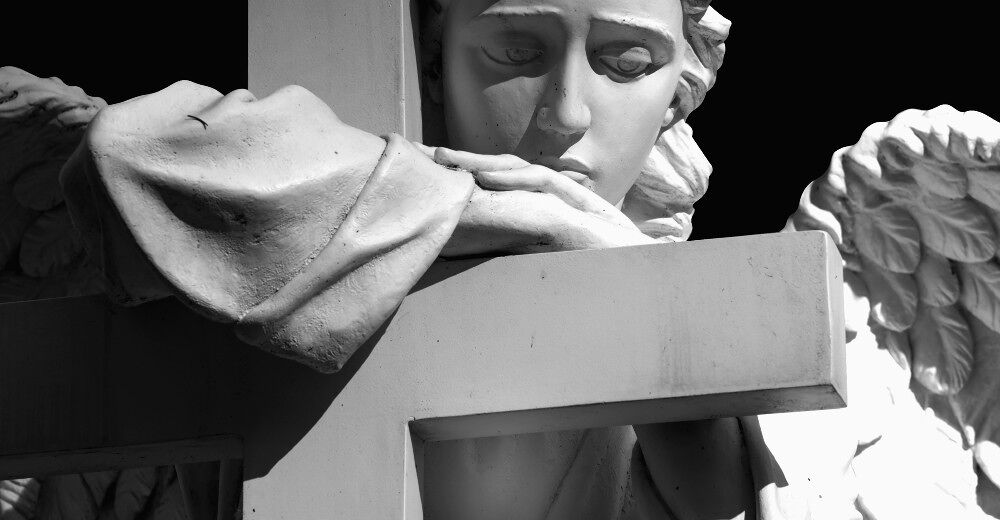 A statue of an angel draped over a cross