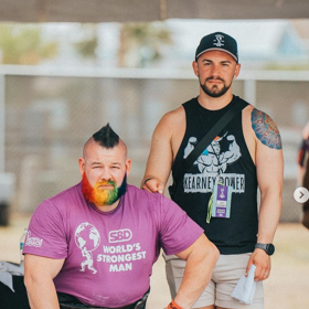 The “World’s Strongest Gay” retires as a winner & he’s making our hearts melt alongside his adorable husband