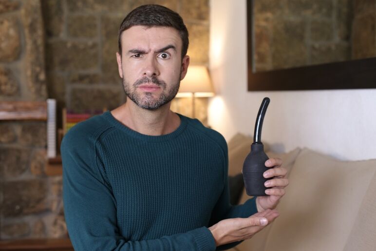 A man holds a douching bulb